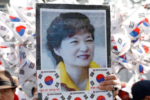 Pendukung presiden Korea Selatan dimakzulkan Park Geun-hye membawa foto Park dalam aksi di depan kantor jaksa di Seoul, Korea Selatan. - Reuters
