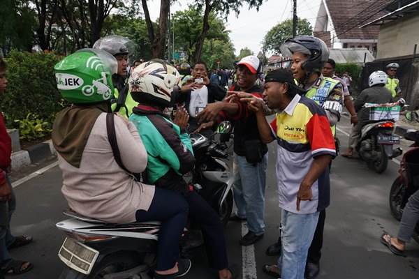Ilustrasi: Polisi menghalau pengemudi angkutan umum yang melakukan penyisiran terhadap ojek online di Jalan TMP Taruna, Tangerang, Banten, Rabu (8/3/2017). Dalam penyisiran itu pengemudi angkutan umum meminta ojek 