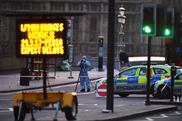Penyelidik forensik bekerja di lokasi setelah sebuah serangan di Westminster Bridge di London - Reuters/Hannah McKay