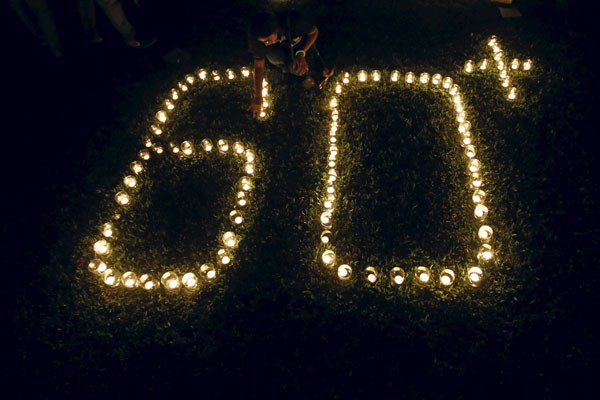 Dokumentasi seorang wanita menyalakan lampu membentuk angka 60 mewakili 60 menit Jam Bumi, saat peringatan Jam Bumi di Kolombo, Sabtu (19/3/16). - Reuters