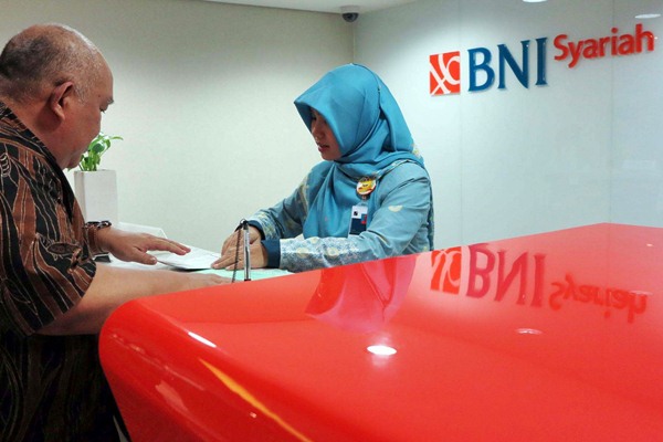 Karyawati PT Bank Negara Indonesia (BNI) Syariah melayani nasabah di Jakarta, Senin (6/3). - JIBI/Nurul Hidayat