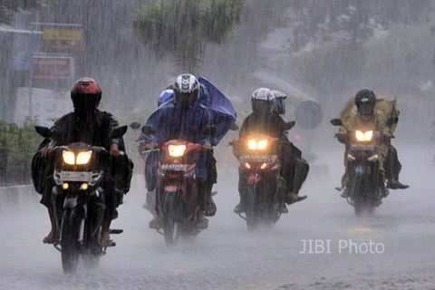 Pengendara sepeda motor menembus hujan deras. - .Bisnis