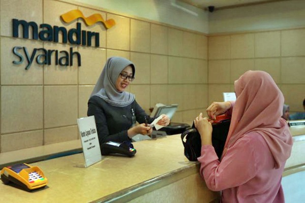 Karyawati melayani nasabah di kantor cabang Bank Syariah Mandiri di Jakarta, Kamis (9/3). - JIBI/Nurul Hidayat