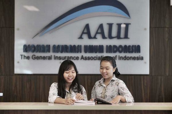 Karyawan berkomunikasi di dekat logo beberapa industri asuransi di kantor Asosiasi Asuransi Jiwa Indonesia (AAJI), di Jakarta. - JIBI/Nurul Hidayat