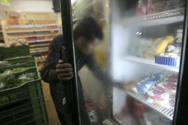 Ilustrasi: Seseorang mengambil minuman yogurt dari lemari es - Reuters/Parivartan Sharma