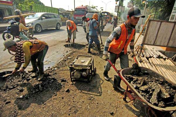 Pekerja melakukan perbaikan jalan di jalur mudik - Antara/Oky Lukmansyah