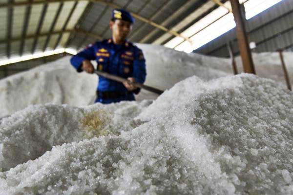 Petugas memeriksa timbunan garam milik PT Garam (persero) yang disegel di dalam gudang oleh Tim Satgas Pangan Mabes Polri di Gresik, Jawa Timur, Rabu (7/6). - Antara/Zabur Karuru