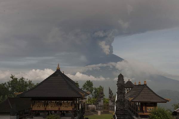 Asap dan abu vulkanik menyembur dari kawah Gunung Agung di Pura Lempuyang, Karangasem, Bali, Senin (27/11). Pusat Vulkanologi dan Mitigasi Bencana Geologi menaikkan status Gunung Agung dari level siaga ke awas setelah terjadinya peningkatan letusan dengan semburan asap dan abu vulkanik hingga ketinggian 3.400 meter. ANTARA FOTO - Nyoman Budhiana