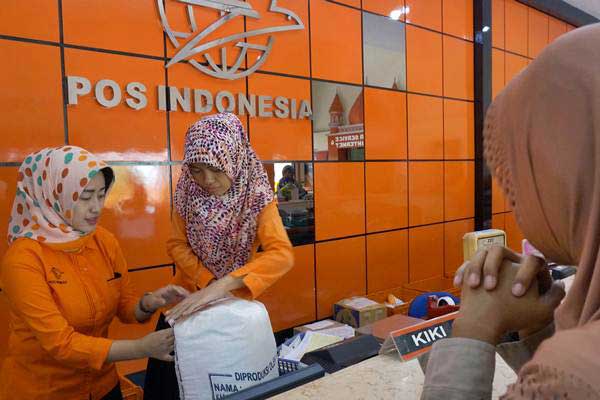 Ilustrasi: Petugas melayani jasa pengiriman paket barang di PT Pos Indonesia, Tulungagung, Jawa Timur, Selasa (13/6). - Antara/Destyan Sujarwoko