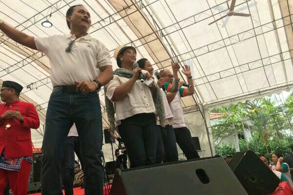 Menlu Retno Marsudi dengan Menteri BUMN Rini Soemarno mendendangkan lagu Terajana menghibur TKI di Singapura, Minggu (11/3).(Hendri T. Asworo - Bisnis)
