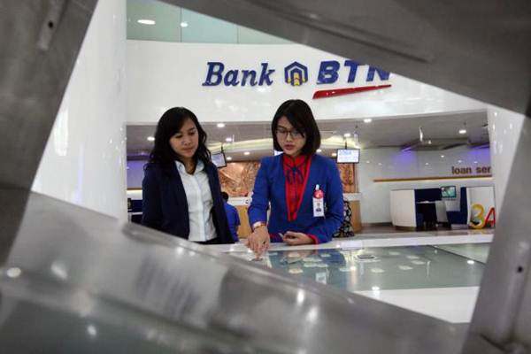 Karyawati PT Bank Tabungan Negara Tbk memberikan penjelasan mengenai produk perbankan kepada nasabah di Jakarta, Senin (8/1). - JIBI/Dedi Gunawan