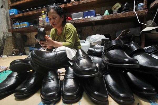 Pekerja menyelesaikan pembuatan sepatu berbahan kulit, di Surabaya, Jawa Timur, Kamis (23/3). - Antara/Moch Asim