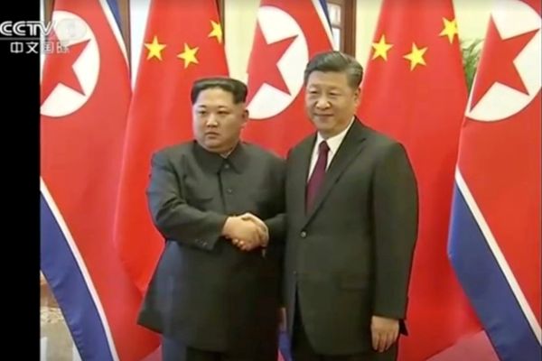 Pemimpin Korea Utara Kim Jong Un bersalaman dengan Presiden China Xi Jinping dalam pertemuan kedua pihak di Beijing, China, dalam foto yang diambil dari tayangan stasiun televisi CCTV China, Rabu (28/3). - Reuters