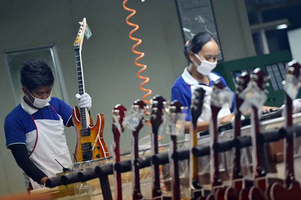 Pekerja menyelesaikan pembuatan gitar listrik di pabrik alat musik Cileungsi, Kabupaten Bogor, Jawa Barat, Selasa (27/3/2018). - ANTARA/Wahyu Putro A
