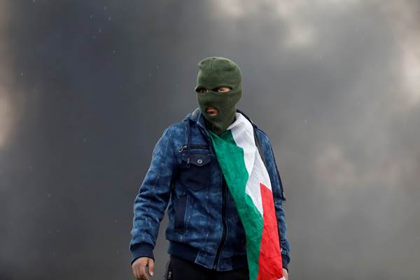 Seorang demonstran dari pihak Palestina saat bentrok dengan pasukan Israel di dekat Nablus, di Tepi Barat. - Reuters