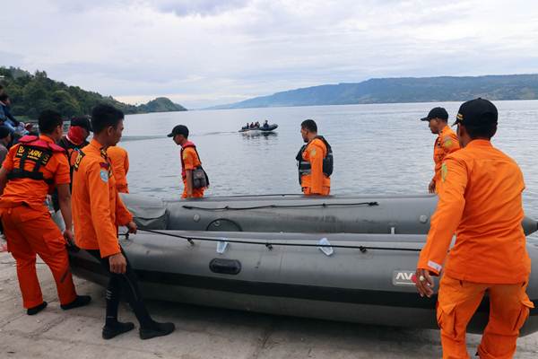 Personel Basarnas mengangkat perahu karet saat akan melakukan pencarian korban KM Sinar Bangun yang tenggelam di Danau Toba, Simalungun, Sumatra Utara, Rabu (20/6/2018). - ANTARA/Irsan Mulyadi