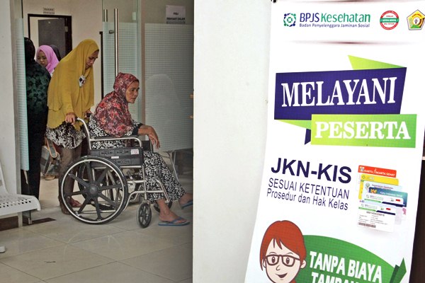 Pasien peserta BPJS Kesehatan didorong  menggunakan kursi roda usai pemeriksaan di Kendari, Sulawesi Tenggara, Senin (13/3). - Antara/Jojon