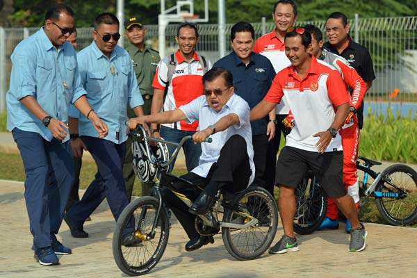 Wakil Presiden Jusuf Kalla (tengah) mencoba naik sepeda BMX ketika meninjau venue BMX di BMX International Center Pulomas, Jakarta, Jumat (29/6/2018). - ANTARA/Wahyu Putro A