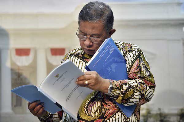 Menko Perekonomian Darmin Nasution membaca berkas Paket Kebijakan Ekonomi XV di Kantor Presiden, Jakarta, Kamis (15/6). - Antara/Puspa Perwitasari