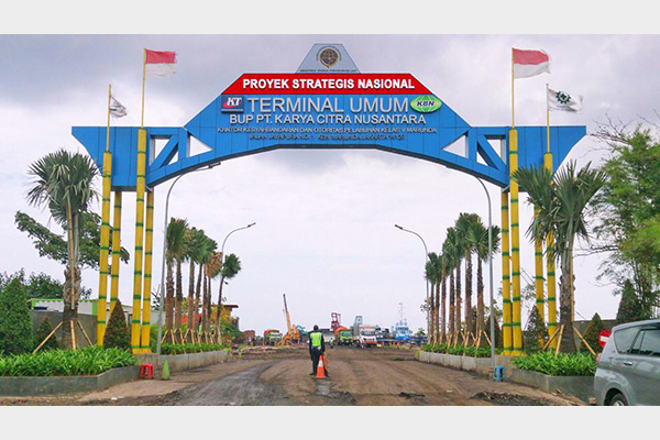  Kendaraan dan alat berat tampak dari gerbang KCN Marunda (rancangan gerbang terbaru). Pembangunan untuk meningkatkan kapasitas pelabuhan yang masuk dalam Proyek Strategis Nasional ini terus dilakukan. Hingga saat ini KCN baru mengoperasikan Pier I sepanjang 800 meter dari tiga Pier yang direncanakan total 5.350 meter. 