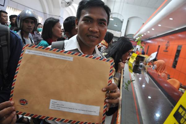 Seorang pelamar calon pegawai negeri sipil (CPNS) memperlihatkan berkas pendaftaran lamarannya untuk dikirim di Kantor Pos Besar Medan, Sumatera Utara, Senin (15/10).  - Antara