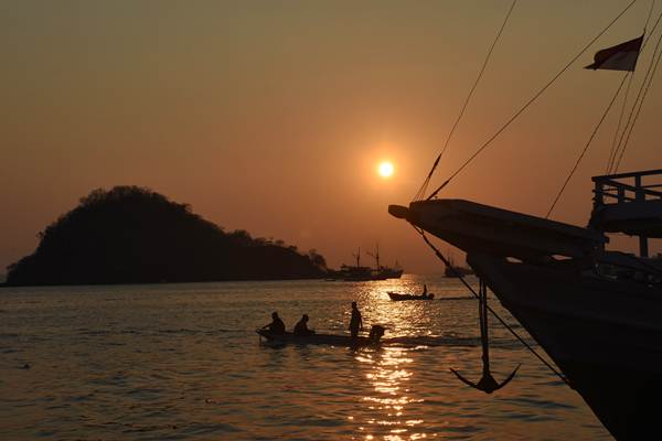 Nelayan melintas saat matahari tenggelam di perairan Labuan Bajo, Manggarai Barat, Nusa Tenggara Timur, Jumat (12/10/2018). - ANTARA/Indrianto Eko Suwarso 