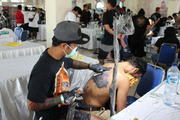 Salah satu seniman tato mengikuti Magic Ink Tattoo Contest 2018 di Bali Creative Industry Center pada Sabtu (24/11/2018). - Bisnis.com/Ni Putu Eka Wiratmini