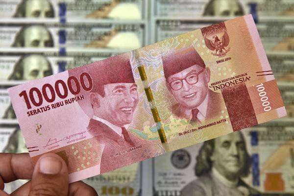 Petugas jasa penukaran valuta asing memeriksa lembaran mata uang rupiah dan dollar AS di Jakarta, Senin (2/7/2018). - ANTARA/Puspa Perwitasari