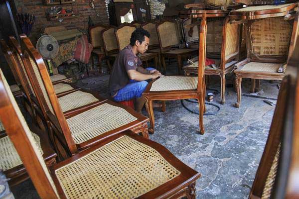 Pekerja menyelesaikan pembuatan kursi rotan - ANTARA/Maulana Surya