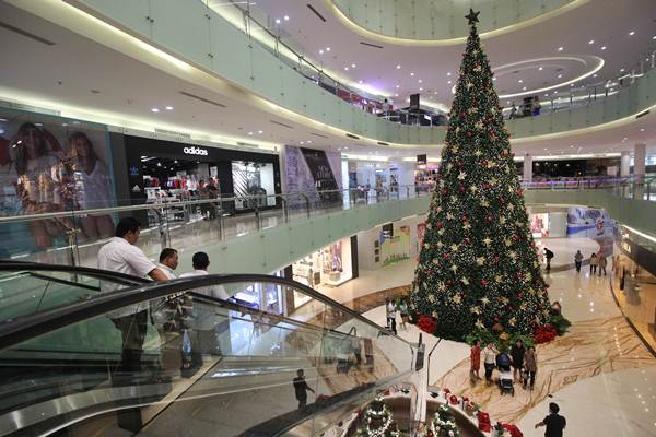 Pengunjung melihat pohon Natal berukuran 15 meter di salah satu pusat perbelanjaan di Surabaya, Jawa Timur, Senin (17/12/2018). - ANTARA/Moch Asim
