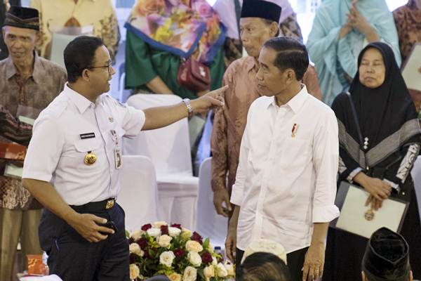 Presiden Joko Widodo (kedua kanan) berbincang dengan Gubernur DKI Jakarta Anies Baswedan (kiri) usai menyerahkan Sertifikat Tanah untuk Rakyat di Cengkareng, Jakarta, Rabu (9/1/2019). - ANTARA/Puspa Perwitasari