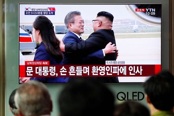 Warga Korea Selatan (Korsel) menonton tayangan televisi yang menunjukkan Presiden Korsel Moon Jae-in berpelukan dengan pemimpin tertinggi Korea Utara (Korut) Kim Jong Un ketika tiba di Pyongyang, Korut, Selasa (18/9). - Reuters/Kim Hong/Ji