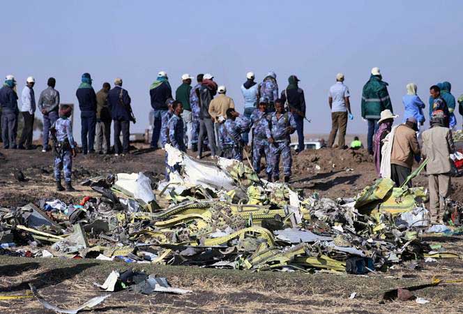 Polisi berdiri di lokasi jatuhnya pesawat Ethiopian Airlines dengan nomor penerbangan ET 302, di dekat Kota Bishoftu, 62 kilometer dari tenggara Ibukota Addis Ababa, Ethiopia, Minggu (10/3/2019). - REUTERS/Tiksa Negeri