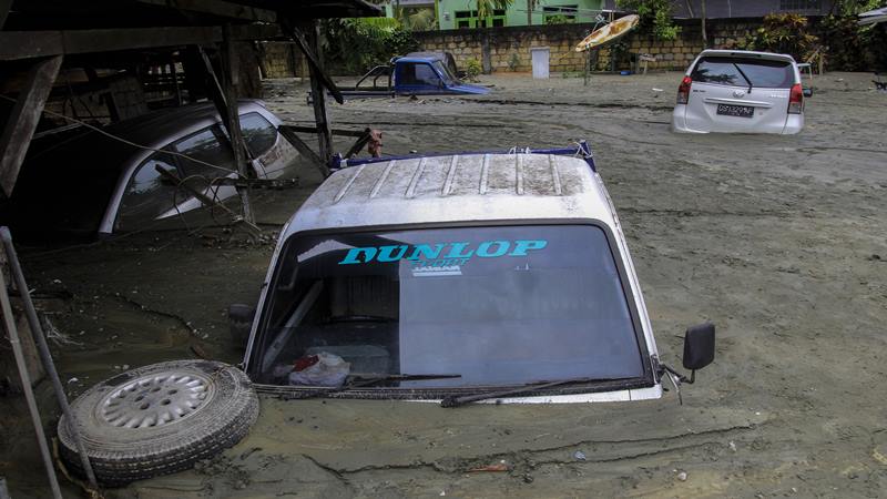 Sejumlah kendaraan terendam lumpur saat banjir bandang di Sentani, Kabupaten Jayapura, Papua, Minggu (17/3 - 2019).