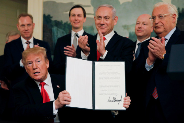 Perdana Menteri (PM) Israel Benjamin Netanyahu (ketiga kanan) bertepuk tangan di belakang Presiden AS Donald Trump (bawah kiri) yang menunjukkan dokumen pengakuan AS atas kedaulatan Israel di Dataran Tinggi Golan dalam sebuah pertemuan di Gedung Putih, Washington, AS, Senin (25/3/2019). - Reuters/Carlos Barria