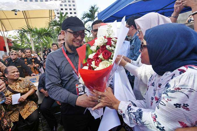 Penyidik KPK Novel Baswedan (tengah) menerima karangan bunga dari warga saat menghadiri peringatan dua tahun kasus kekerasan yang menimpanya di depan gedung KPK, Jakarta, Kamis (11/4/2019). - ANTARA/Indrianto Eko Suwarso