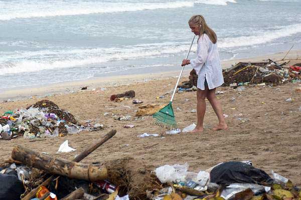 Wisatawan mancanegara (wisman) membersihkan sampah yang berserakan di kawasan Pantai Kuta, Badung, Bali, Selasa (1/1/2019). - ANTARA/Nyoman Hendra Wibowo