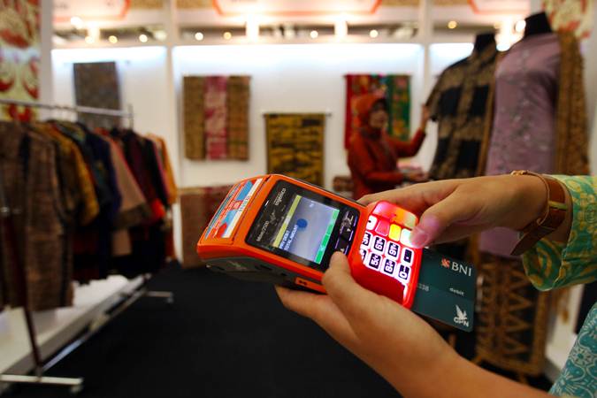 Pengunjung melakukan transaksi saat berbelanja batik di booth BNI saat acara Gelar Batik Nusantara di Jakarta, Rabu (8/5/2019). - Bisnis/Abdullah Azzam