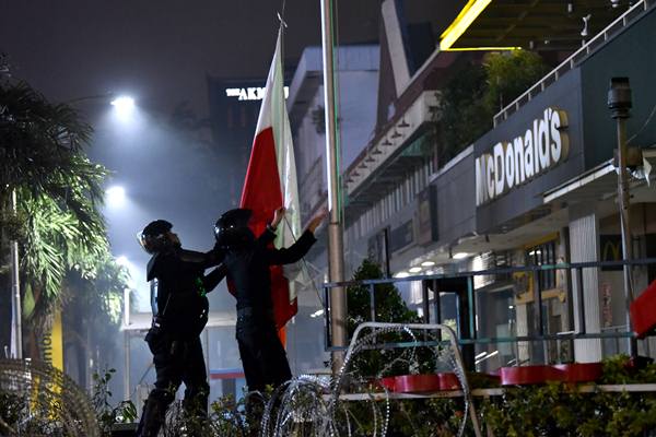 Brimob memasang bendera Merah Putih di kawasan Sarinah, Jl MH Thamrin saat unjuk rasa, Rabu (22/5/2019). - Antara