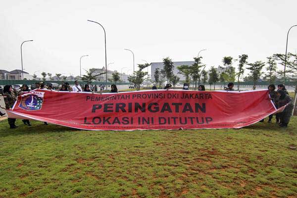 Sejumlah petugas Satuan Polisi Pamong Praja (Satpol PP) membentangkan spanduk penyegelan di Pulau D Reklamasi Teluk Jakarta, Jakarta, Kamis (7/6/2018). - ANTARA/Dhemas Reviyanto