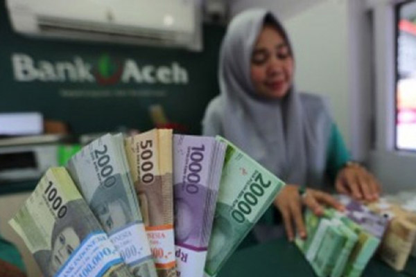 Seorang karyawati menghitung uang di salah satu kantor cabang Bank Aceh. - Antara/Irwansyah Putra