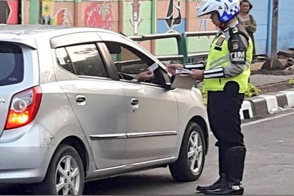 Polisi menilang pengendara yang melanggar Kawasan pembatasan Kendaraan ganjil genap di Jl Kartini Jaksel. - Twitter @tmcpoldametro