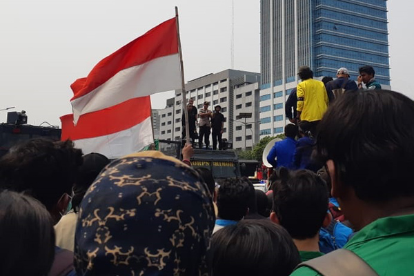 Kapolres Jakarta Pusat Kombes Harry Kurniawan berdiri di atap mobil taktis polisi saat berdialog dengan mahasiswa pengunjuk rasa di depan Gedung DPR pada Selasa 24 September 2019. - Bisnis/Feni Freycinetia