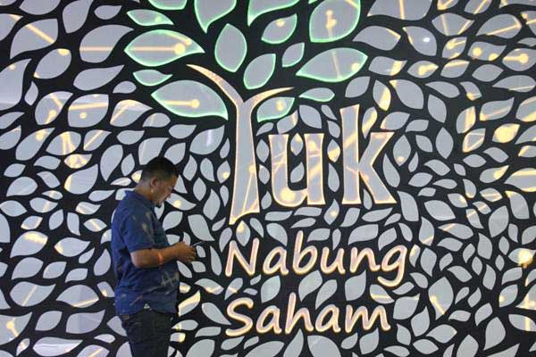 Pengunjung beraktivitas di dekat tulisan Yuk Nabung Saham, di Jakarta, Kamis (3/1/2019). - Bisnis/Dedi Gunawan