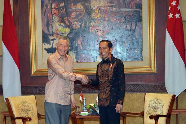 Presiden Joko Widodo (kanan) berjabat tangan dengan Perdana Menteri Singapura Lee Hsien Loong saat mengadakan pertemuan bilateral di sela Pertemuan Tahunan IMF - World Bank Group 2018 di Bali - Antara/Nyoman Budhiana