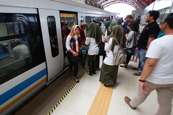Sebagian penumpang bersiap memasuki kereta Light Rail Transit (LRT) Palembang di Stasiun Jakabaring Palembang, Jumat (3/5). Moda transportasi anyar di Palembang tersebut menjadi salah satu daya tarik wisata untuk Bumi Sriwijaya. - Bisnis/Tim Jelajah Infrastruktur Sumatra/Abdullah Azzam