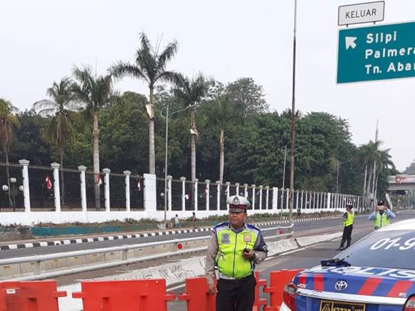 Petugas mengawasi kondisi lalu lintas di lokasi penutupan dan pengalihan arus tol dalam kota. Exit tol DPR/MPR di tutup dan dialihkan keluar Slipi Jaya. - TMCPoldaMetro