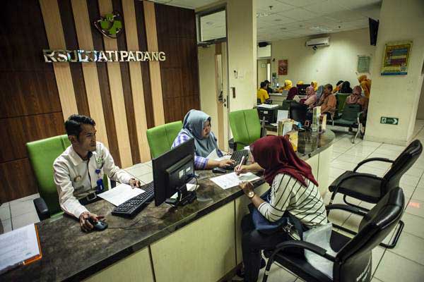 Petugas melayani calon pasien menyelesaikan proses administrasi di RSUD Jati Padang, Jakarta, Senin (7/1/2019). - ANTARA/Aprillio Akbar