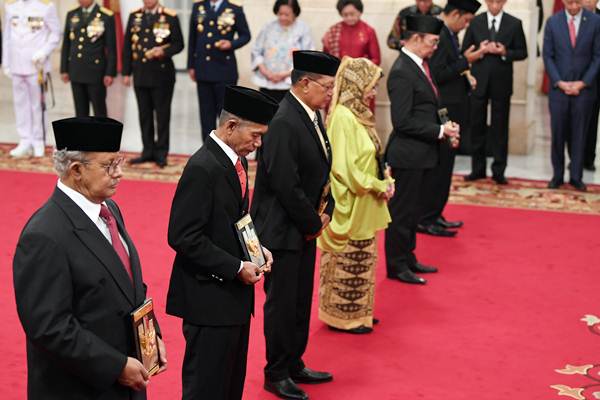 Ahli waris memegang tanda jasa yang diserahkan oleh Presiden Joko Widodo saat penganugerahan gelar pahlawan nasional di Istana Negara, Jakarta, Kamis (8/11/2018). - ANTARA/Wahyu Putro A