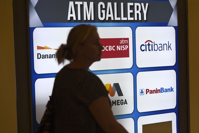 Warga melintasi galeri anjungan tunai mandiri (ATM) di Kebayoran Lama, Jakarta, Senin (5/8/2019). - ANTARA/Aditya Pradana Putra.